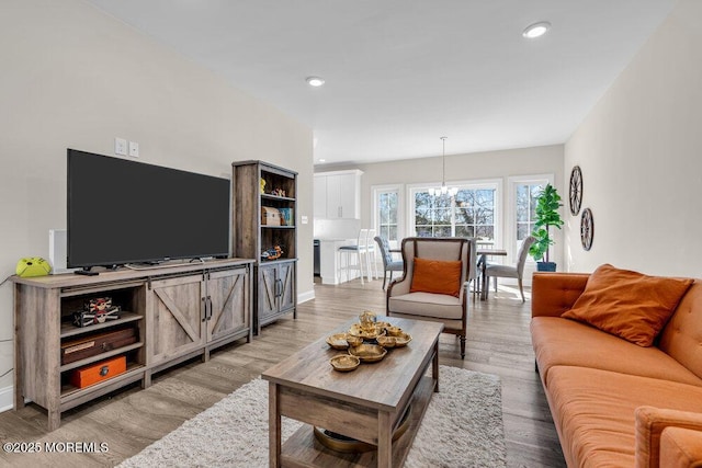 living room featuring a chandelier, light wood-style flooring, and recessed lighting