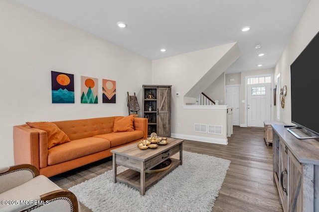 living area featuring stairs, baseboards, dark wood-style flooring, and recessed lighting