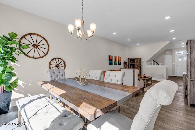 dining area featuring visible vents, wood finished floors, an inviting chandelier, stairs, and recessed lighting