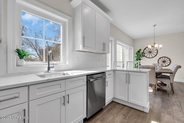 kitchen featuring a chandelier, dark wood-type flooring, a sink, white cabinets, and stainless steel dishwasher