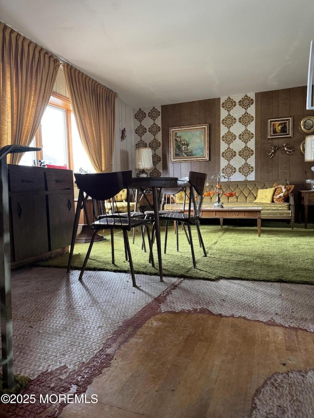 dining space with wallpapered walls and wood-type flooring