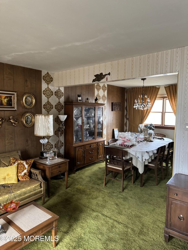 carpeted dining space featuring a notable chandelier and wallpapered walls