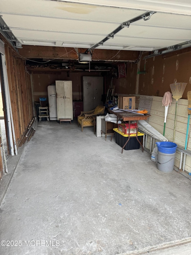 garage featuring a garage door opener and refrigerator