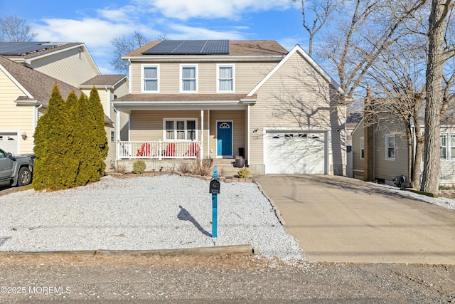 traditional-style house featuring a porch, roof mounted solar panels, and concrete driveway