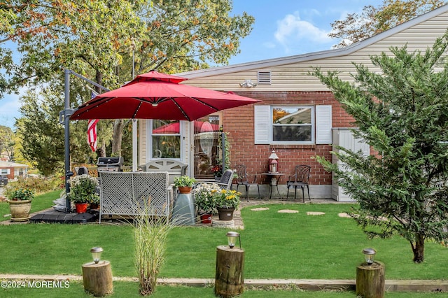 exterior space featuring brick siding and a yard