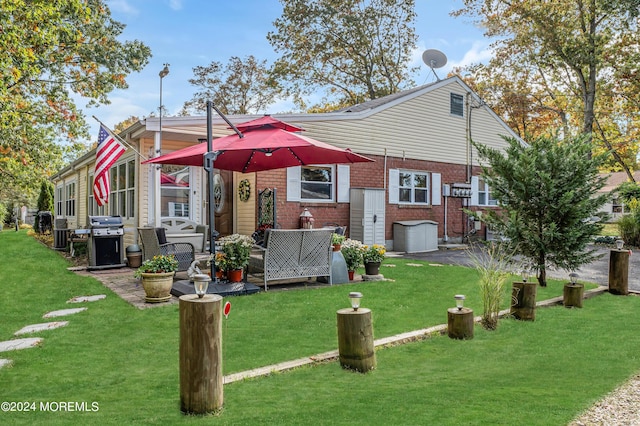 rear view of house with a yard and brick siding