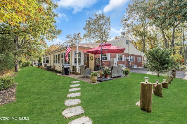 rear view of property featuring central AC, a yard, brick siding, and a patio