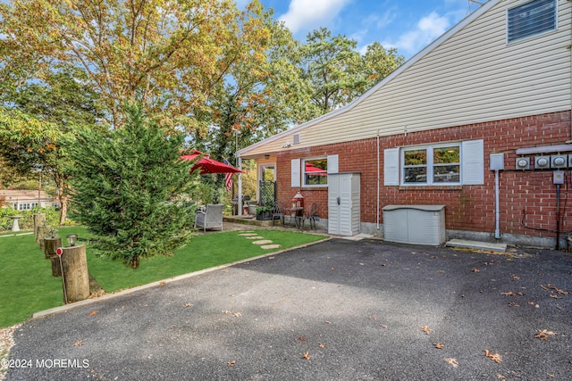 exterior space featuring a front yard, a patio area, and brick siding