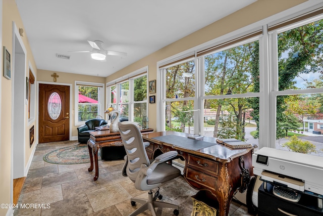 office with stone tile flooring, visible vents, ceiling fan, and baseboards