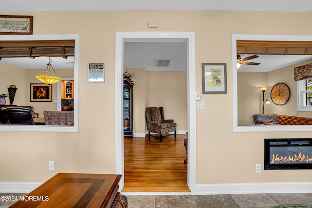 corridor with visible vents, baseboards, and wood finished floors