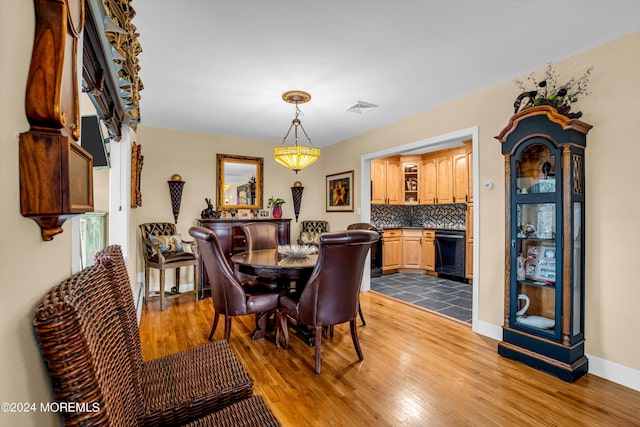 dining space featuring visible vents, baseboards, and wood finished floors