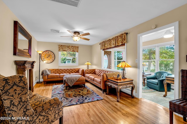 living room with ceiling fan, wood finished floors, and visible vents