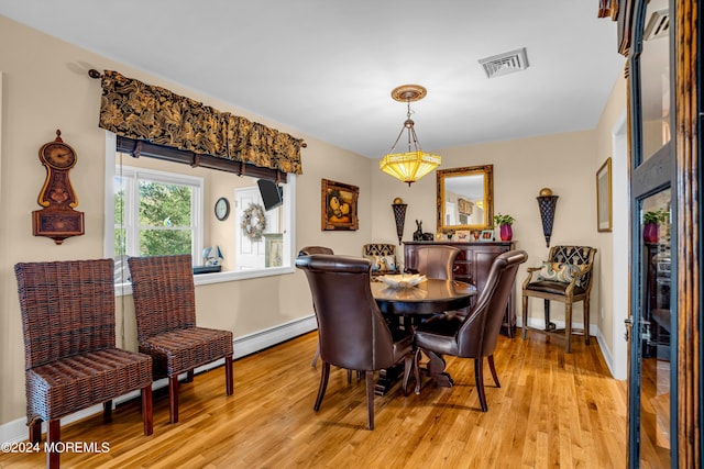 dining room featuring light wood-type flooring, baseboards, visible vents, and a baseboard radiator