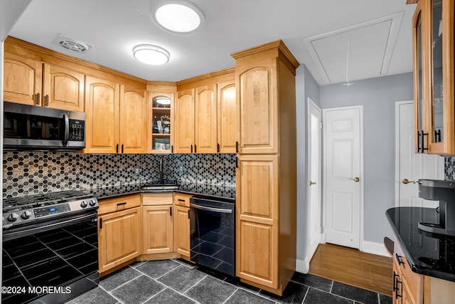 kitchen with stainless steel appliances, a sink, visible vents, tasteful backsplash, and glass insert cabinets