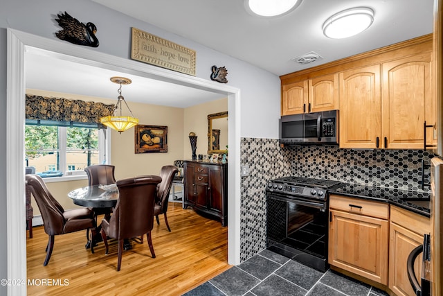 kitchen featuring range with gas cooktop, dark countertops, stainless steel microwave, visible vents, and decorative backsplash