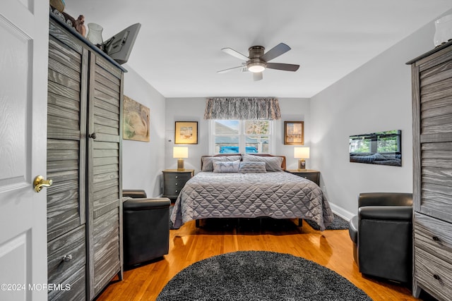 bedroom with light wood-type flooring, baseboards, and a ceiling fan