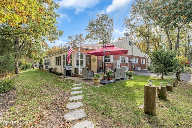 rear view of house featuring a patio, brick siding, and a lawn