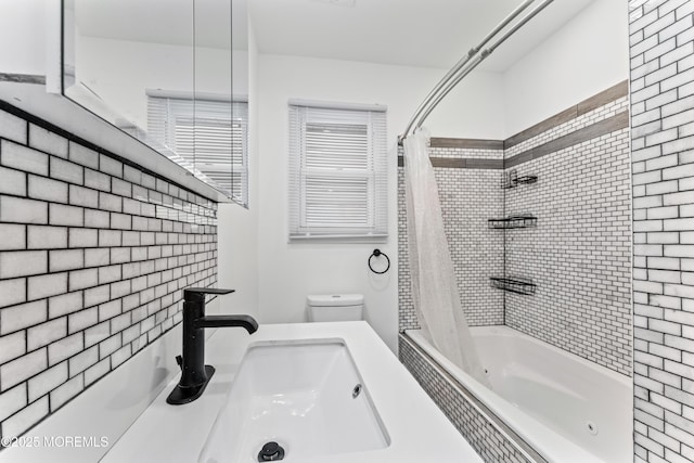 bathroom with toilet, shower / bath combo with shower curtain, and a sink