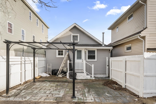 back of house with a fenced backyard, a pergola, and a patio