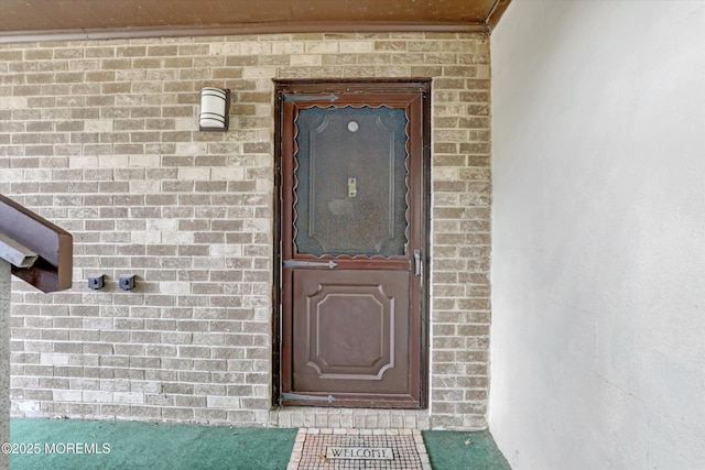 doorway to property featuring brick siding