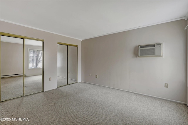 unfurnished bedroom featuring multiple closets, baseboard heating, a wall mounted AC, ornamental molding, and carpet flooring