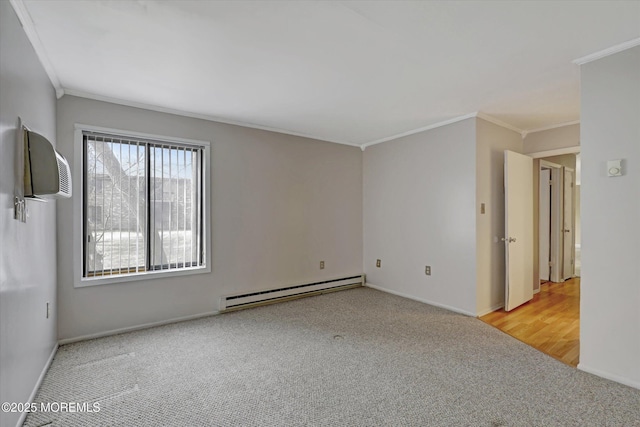 empty room featuring a baseboard heating unit, carpet, crown molding, and baseboards