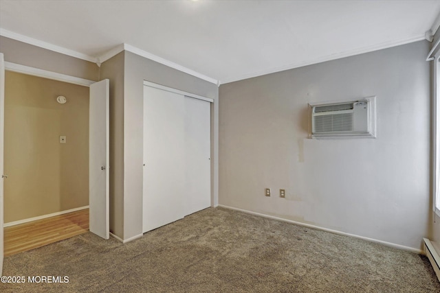 unfurnished bedroom with ornamental molding, a closet, a wall unit AC, and carpet flooring