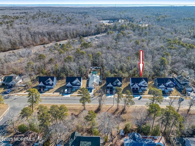 birds eye view of property featuring a forest view