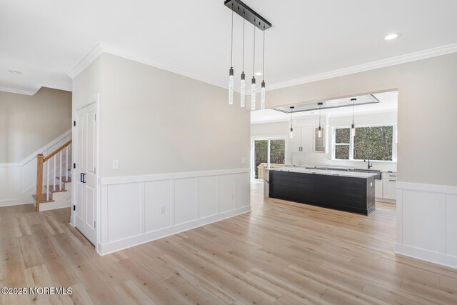 kitchen featuring a center island, light countertops, light wood-style flooring, and white cabinetry