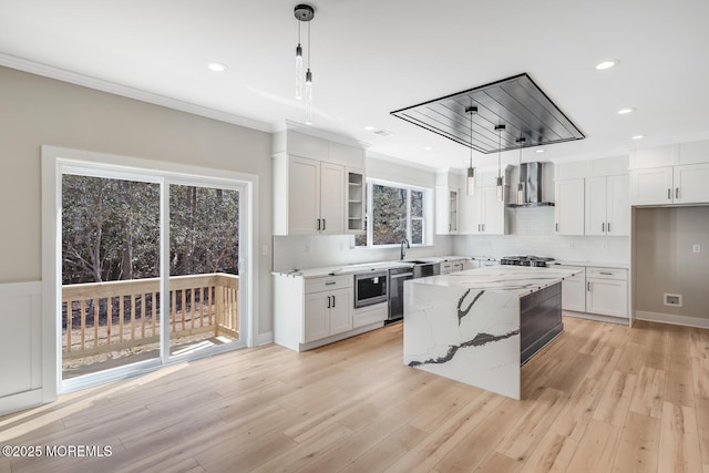 kitchen featuring stainless steel appliances, white cabinetry, crown molding, and wall chimney exhaust hood