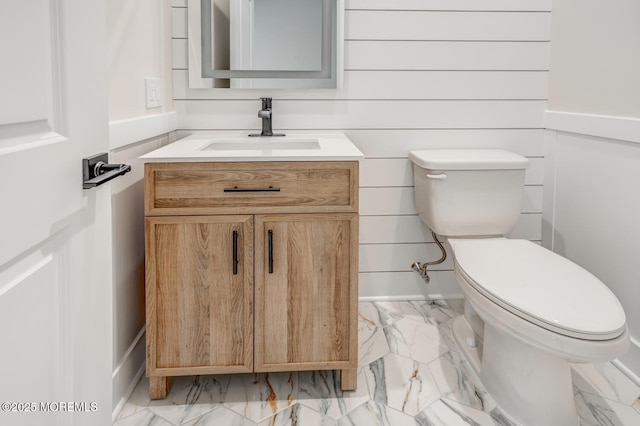 bathroom featuring toilet, marble finish floor, and vanity