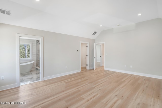 unfurnished bedroom featuring light wood-style flooring, visible vents, and vaulted ceiling