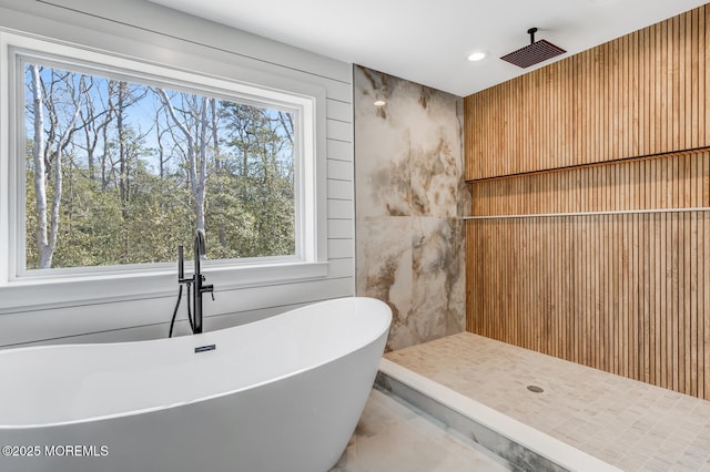 bathroom featuring a freestanding bath, a tile shower, and recessed lighting