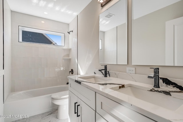 bathroom with a sink, shower / bathing tub combination, toilet, and double vanity