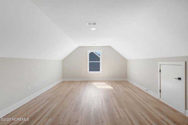 bonus room with lofted ceiling, light wood-style flooring, visible vents, and baseboards