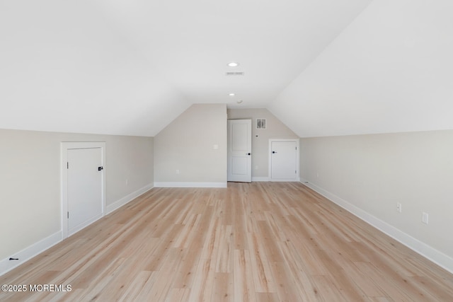 bonus room featuring vaulted ceiling, light wood finished floors, visible vents, and baseboards