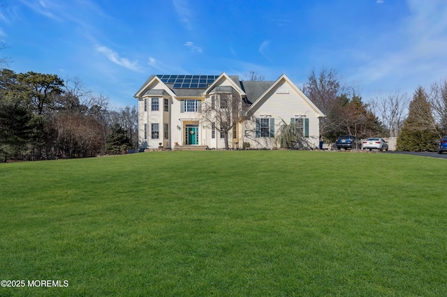 view of front of house with a front lawn and solar panels