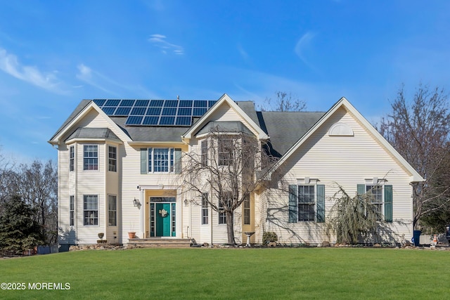 view of front of house featuring solar panels and a front lawn