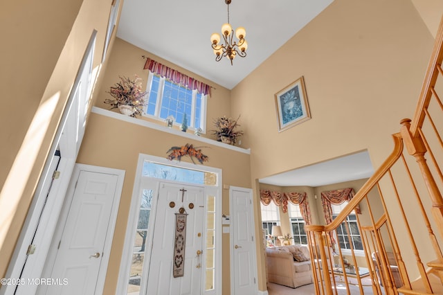 entrance foyer with a towering ceiling, stairs, and a notable chandelier