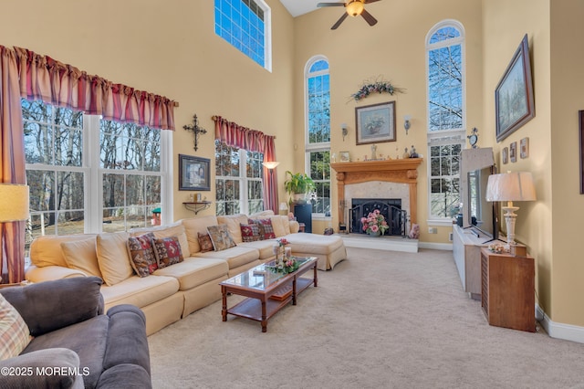 carpeted living area featuring a wealth of natural light, a high end fireplace, and baseboards