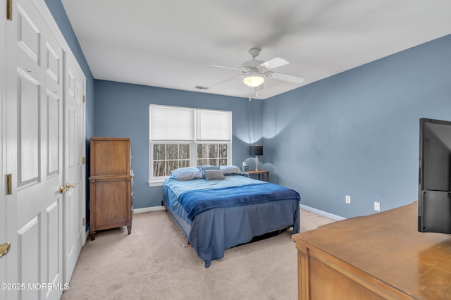 bedroom featuring a ceiling fan, light colored carpet, and baseboards