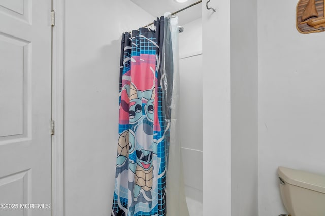 bathroom featuring toilet and a shower with shower curtain