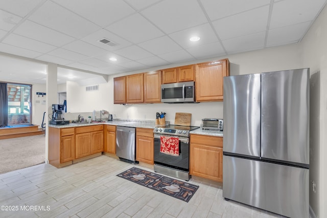 kitchen with appliances with stainless steel finishes, a sink, visible vents, and a toaster