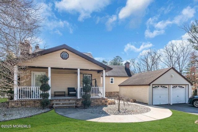 view of front of home with an outbuilding, covered porch, a front yard, a garage, and a chimney