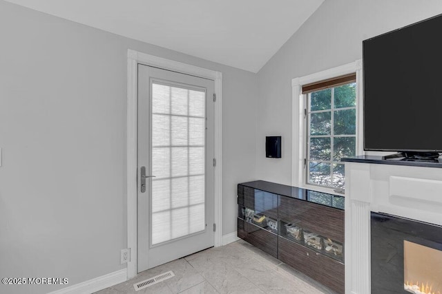 doorway to outside with visible vents, baseboards, and vaulted ceiling