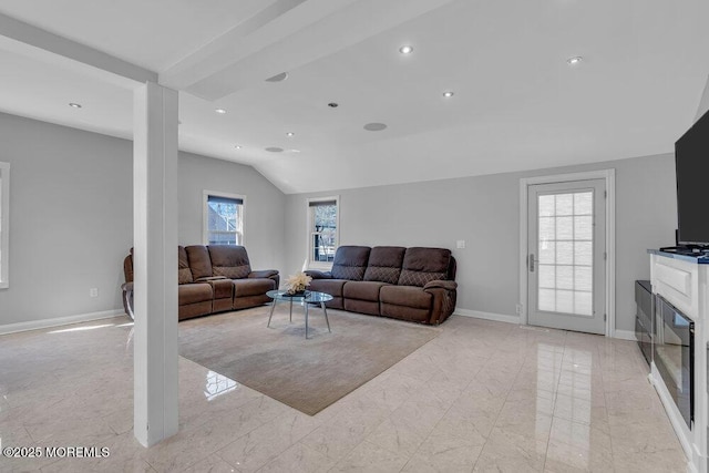 living area with baseboards, vaulted ceiling, recessed lighting, a glass covered fireplace, and marble finish floor