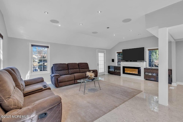 living room featuring lofted ceiling, marble finish floor, a glass covered fireplace, recessed lighting, and baseboards