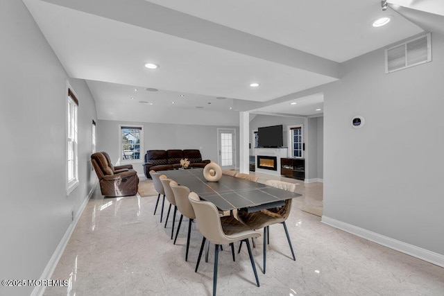 dining room featuring baseboards, visible vents, recessed lighting, a glass covered fireplace, and marble finish floor