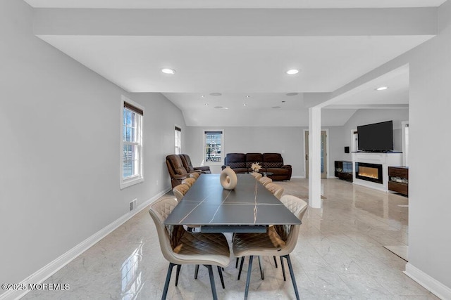 dining area with recessed lighting, baseboards, marble finish floor, and a glass covered fireplace