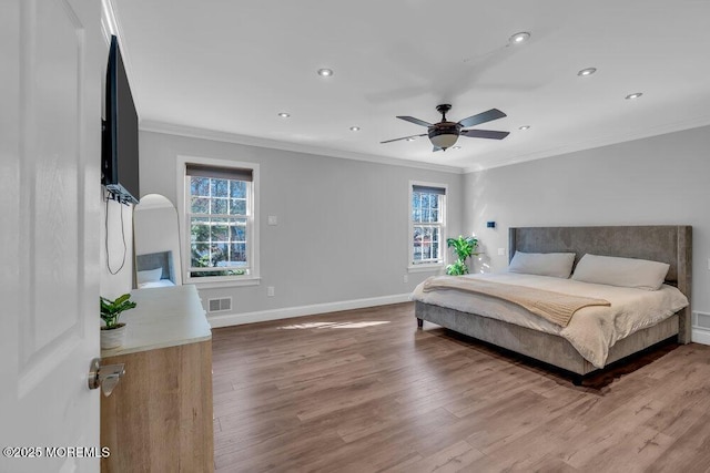 bedroom featuring wood finished floors, visible vents, baseboards, recessed lighting, and crown molding